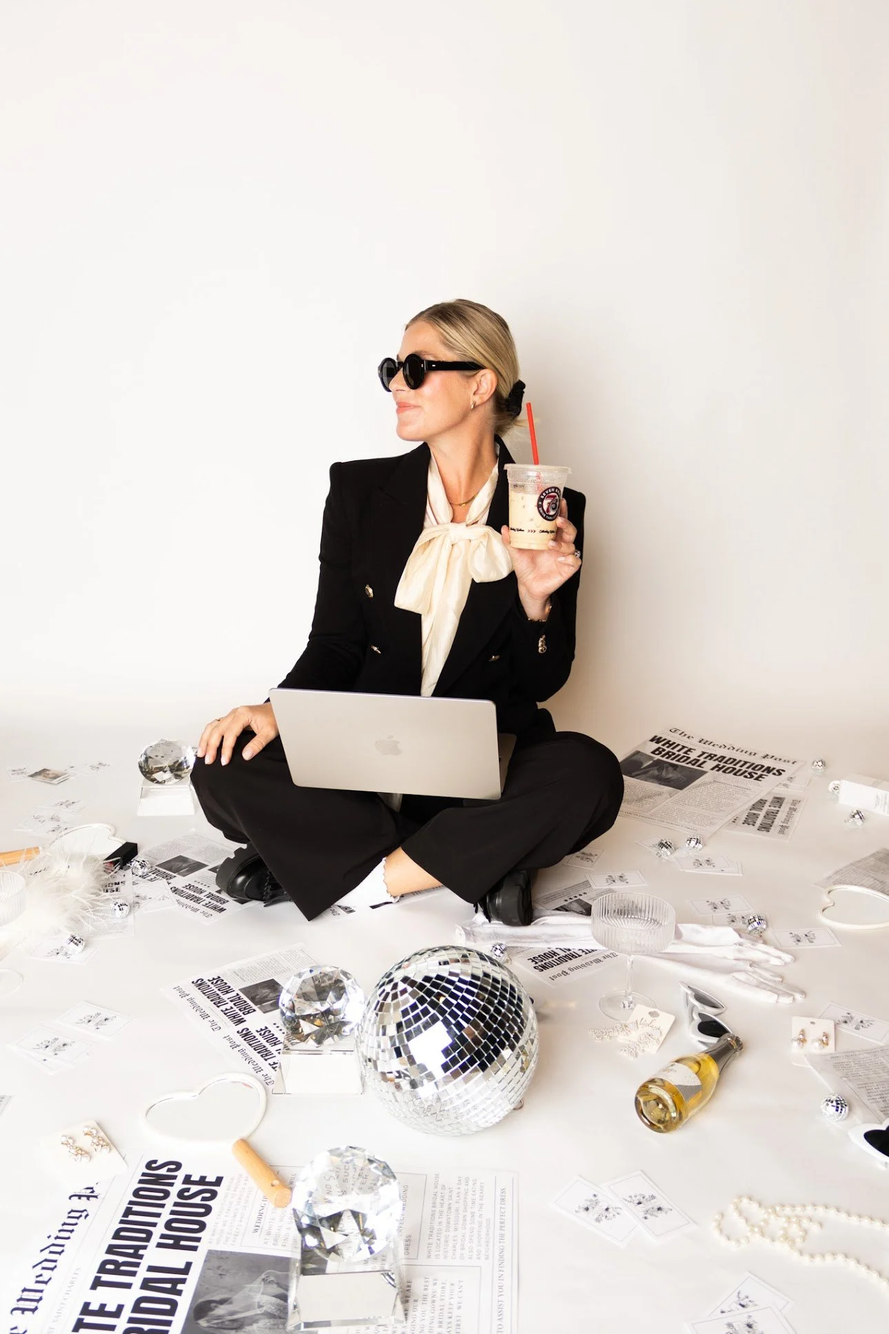 photo of Jessica, the store owner, in a black pant suit with a laptop