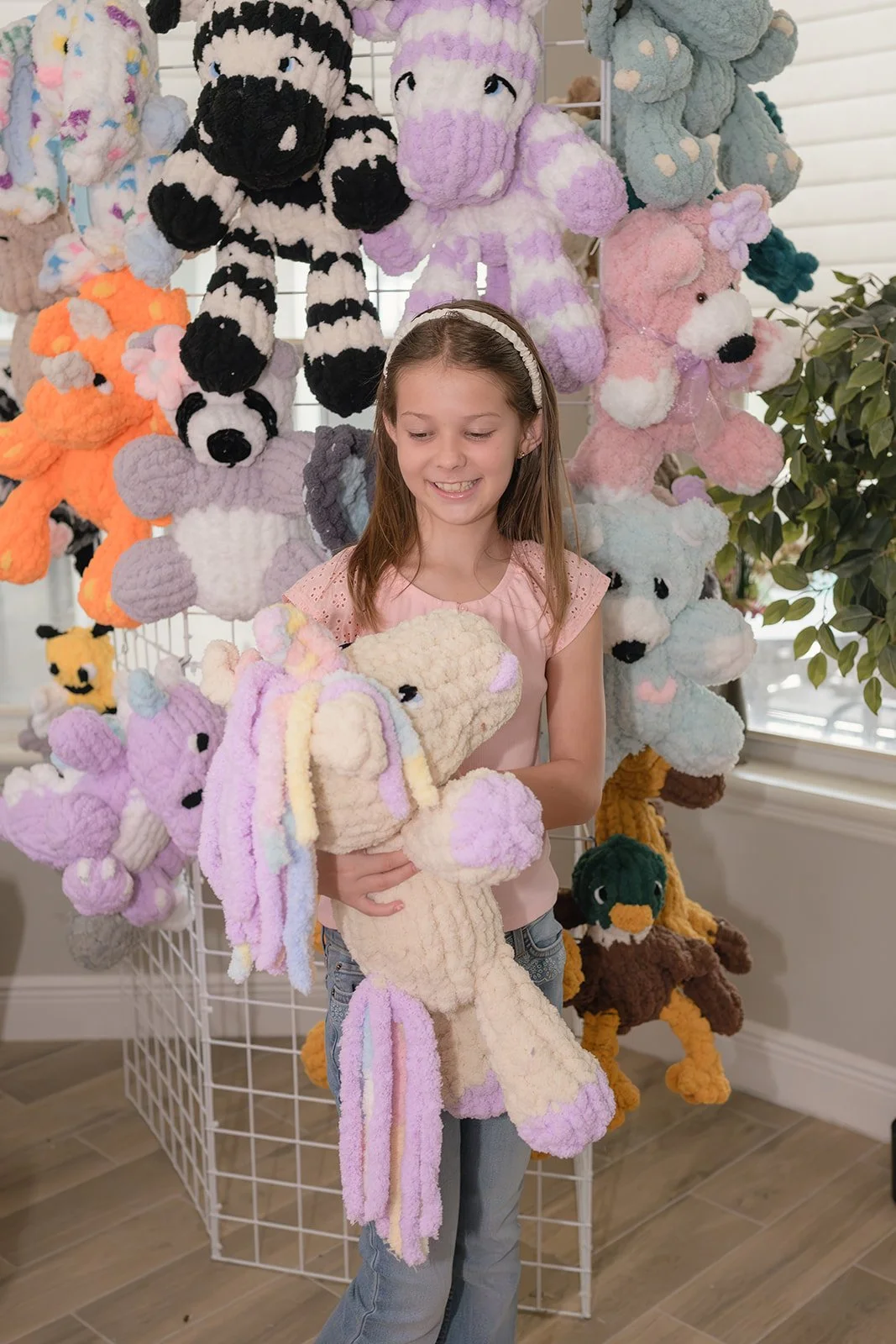 Tiani’s granddaughter holding a handmade Cuddle Companion from the Tender Moments Collection.