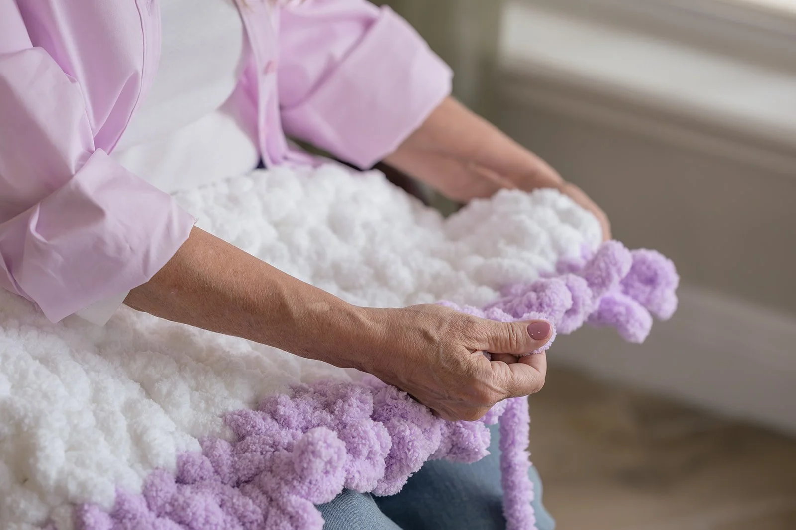 Tiani Mattus handcrafting a chunky knit blanket.
