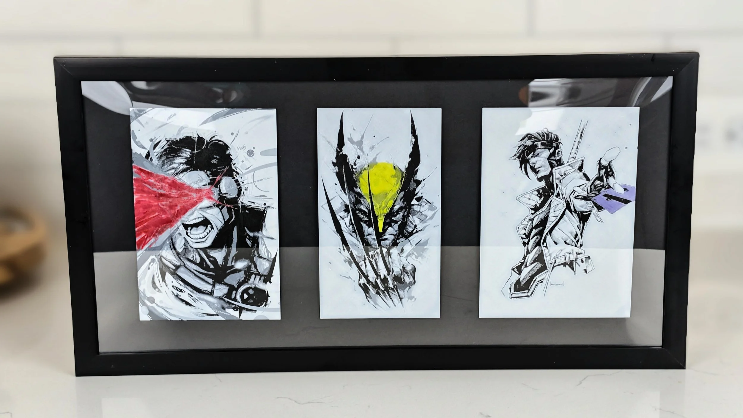 Three black and white anime-style sketches of characters, with the first on the left showing a person with a red burst of color, the middle featuring a figure with yellow and black, and the right depicting a character with spiky hair and a sword.
