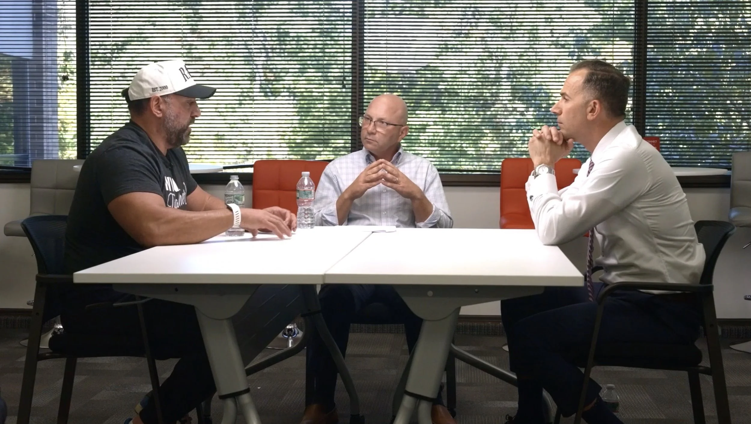 Three men having a business discussion around a conference table in an office