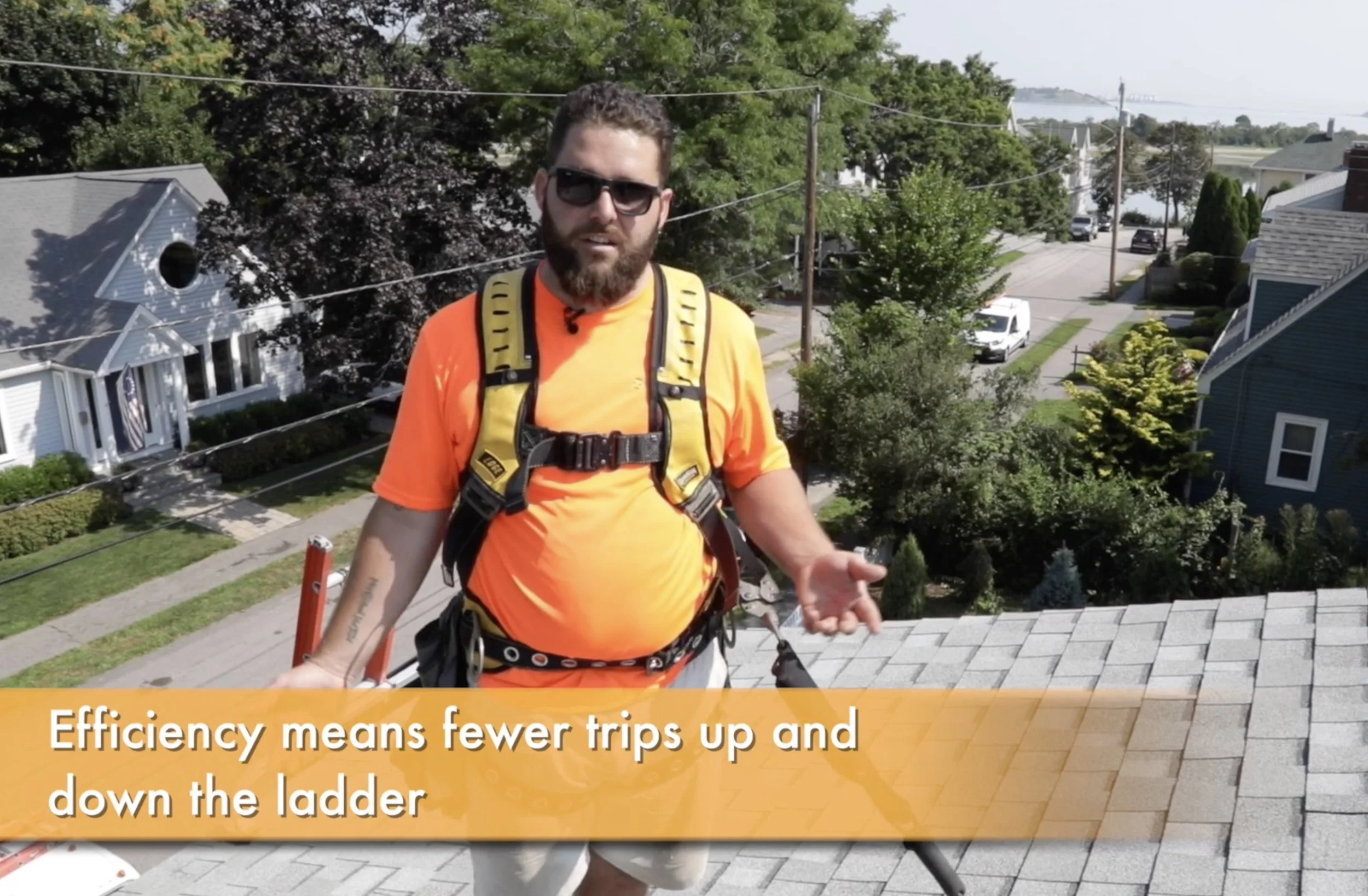 contractor in fall protection harness on a suburban roof