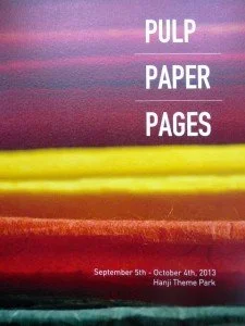 A poster advertising a Pulp Paper Pages event from September 5th to October 4th, 2013, at Hanji Theme Park in South Korea, with colorful horizontal paint streaks in purple, yellow, and red.