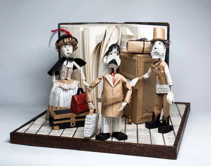 three Small newspaper paper figures stand in a open book