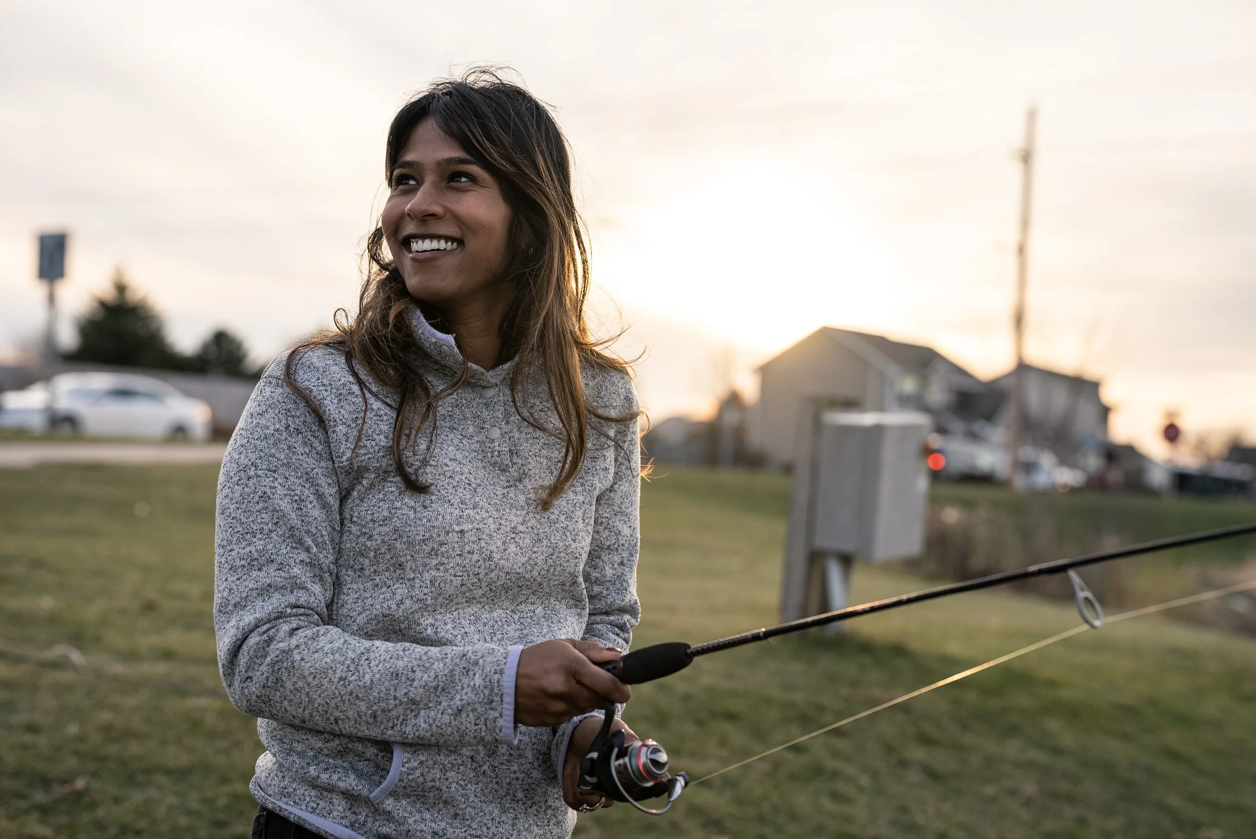 A woman smiling and preparing to fish.