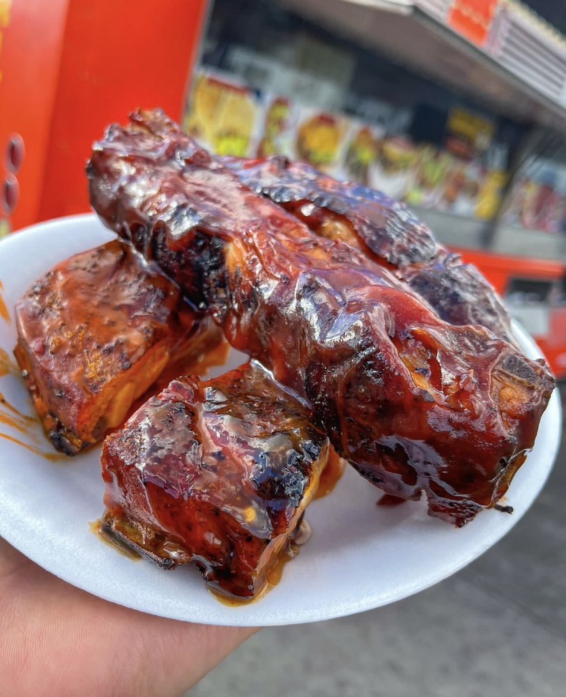 Barbecue pork ribs with sauce on a white paper plate