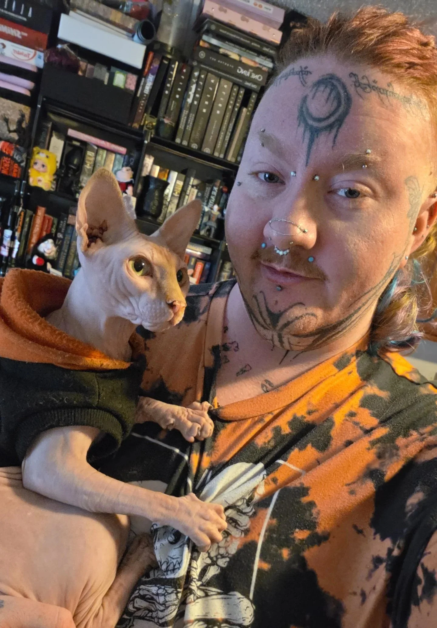 Crybaby Angell, a Colorado tattoo artist posing with his cat, Binx.