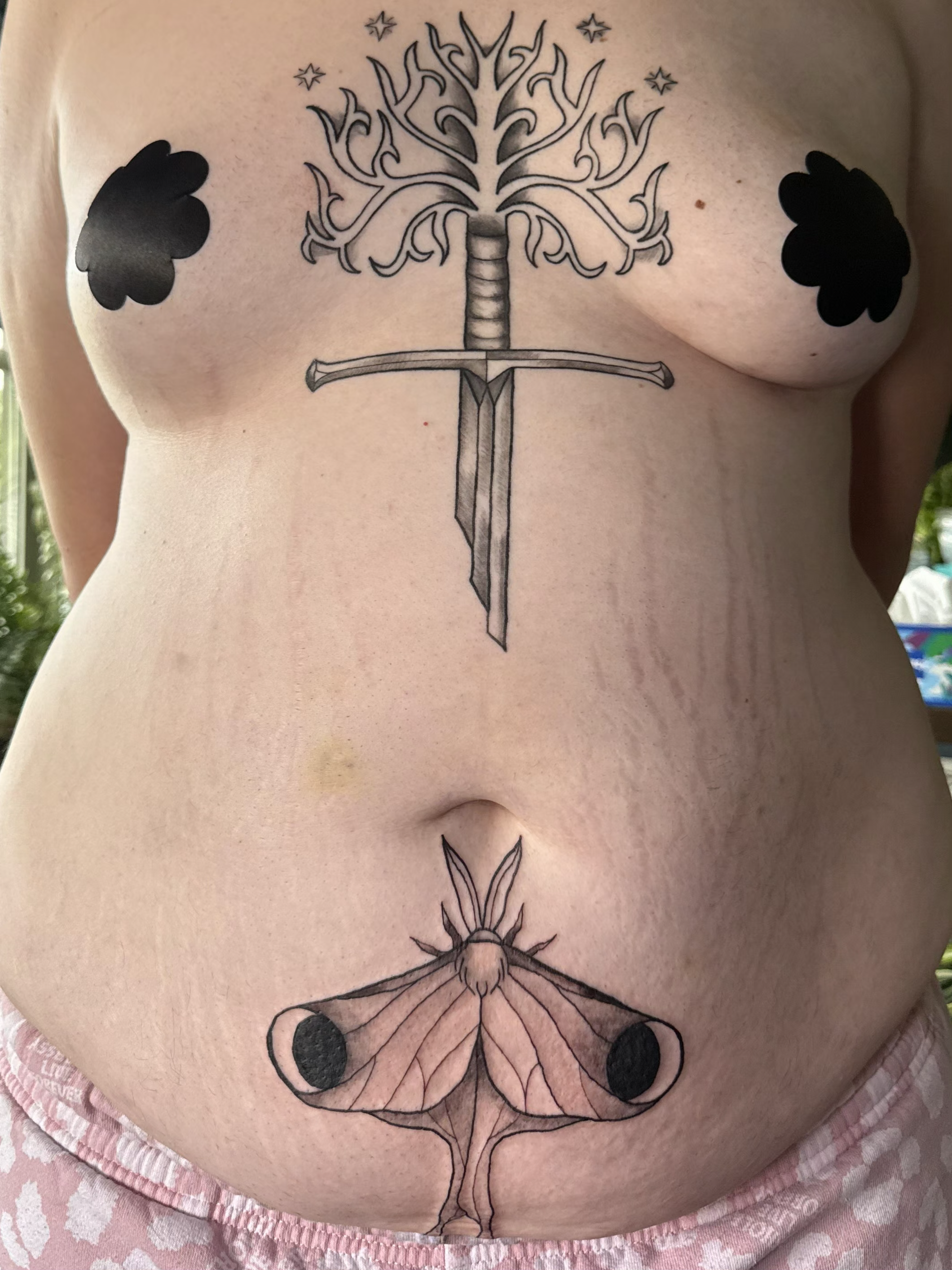 Crybaby Angell, a Colorado tattoo artist tattooed Narsil with the tree of Gondor and a Luna moth on the abdoment and underboob.