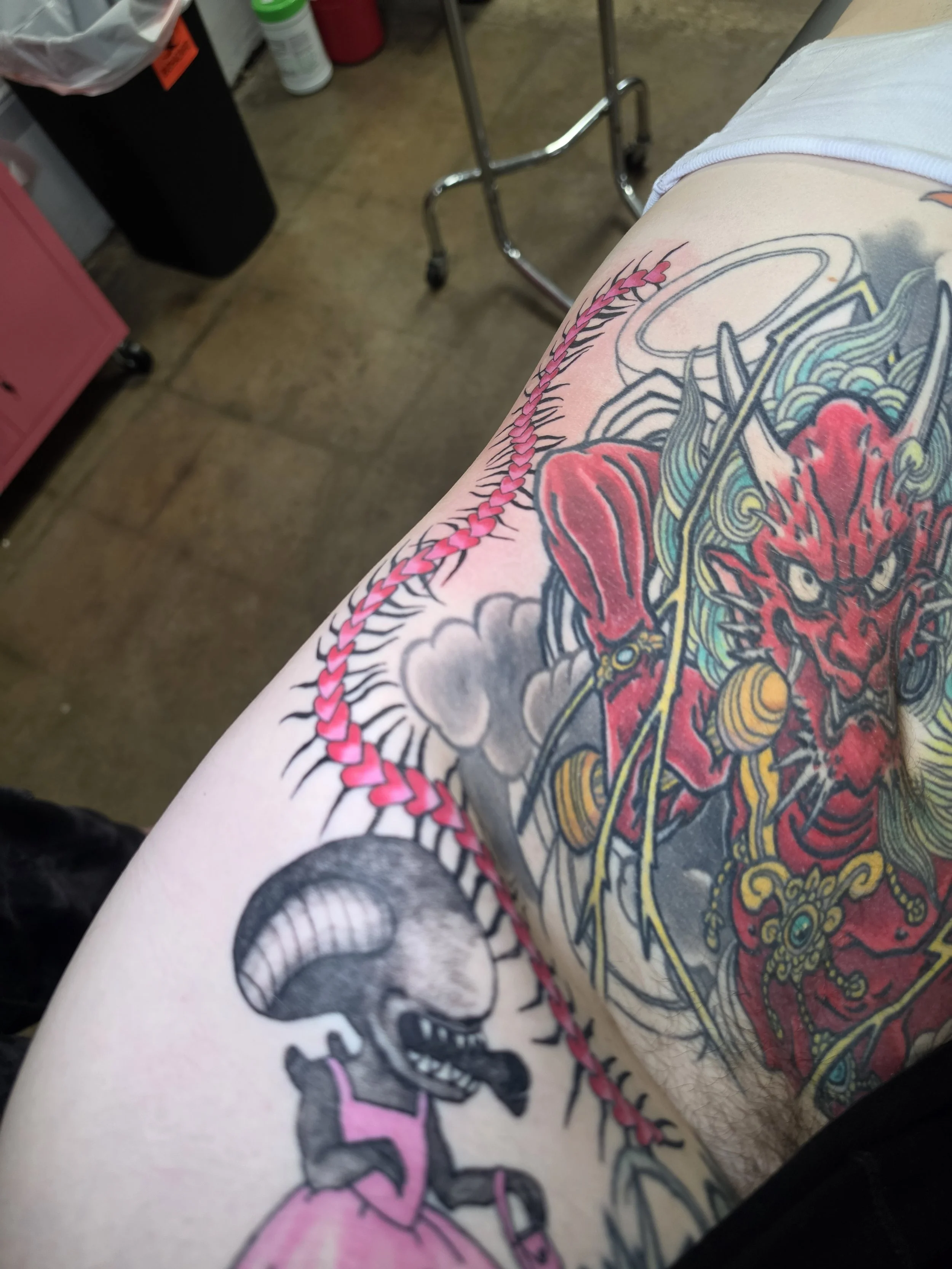 Crybaby Angell, a Colorado tattoo artist tattooed a pink centipede going up this client's side and ribs.