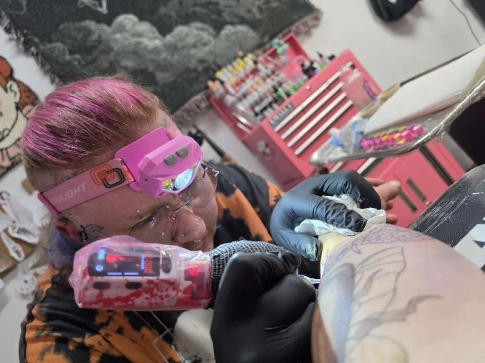 Crybaby Angell, a Colorado tattoo artist tattooing a client's forearm