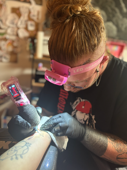 Crybaby Angell, a Colorado tattoo artist tattooing.