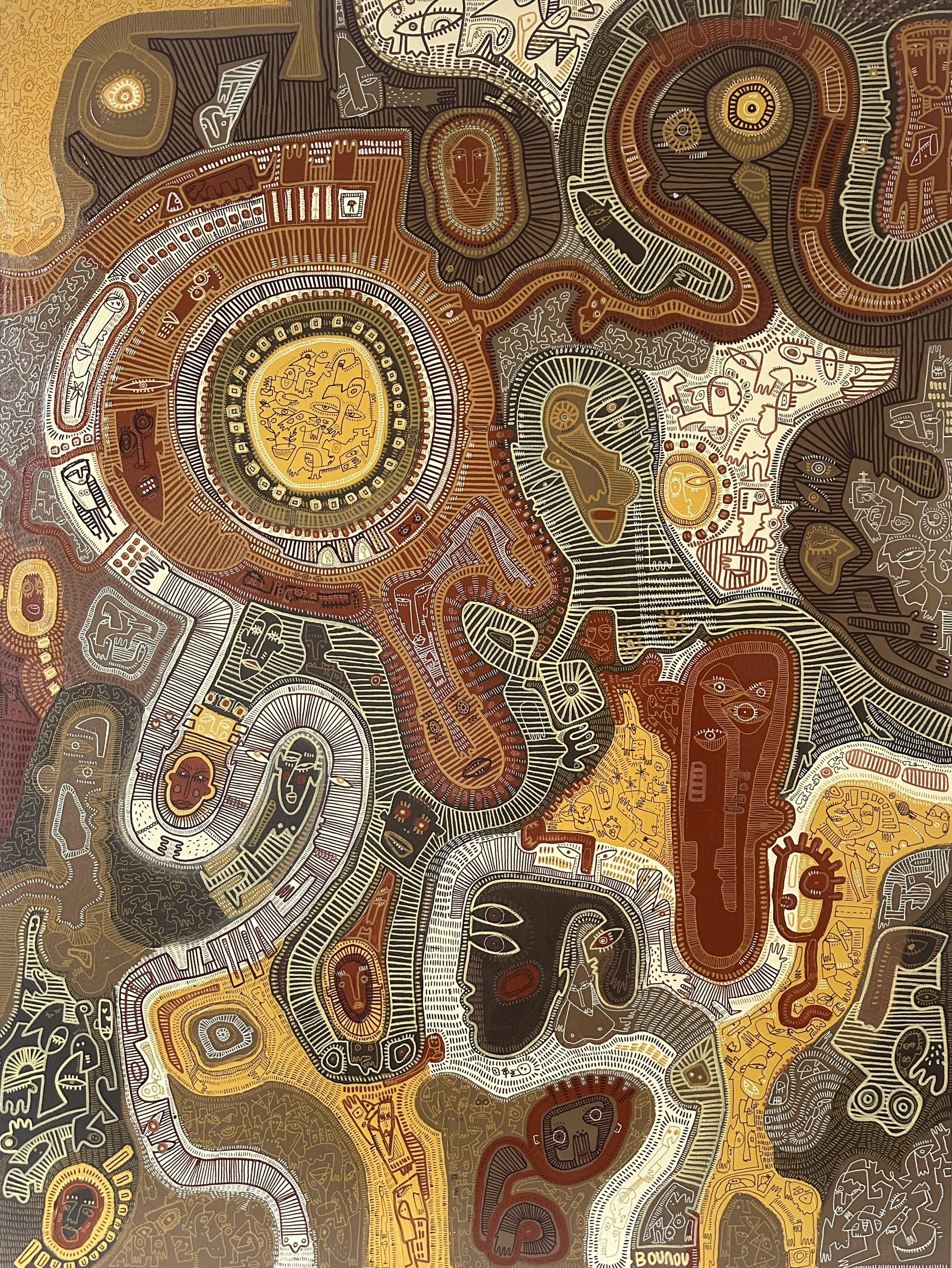 A detailed tribal-style abstract artwork featuring numerous human, animal, and geometric figures and patterns in shades of brown, black, white, and yellow.