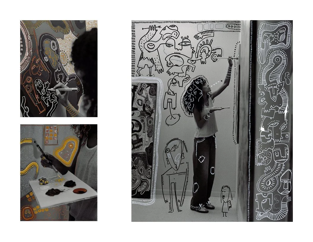 A woman and a child creating abstract, colorful line art on black backgrounds in an art studio.