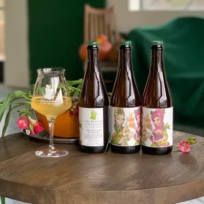 hard cider bottles on a wood table at the good life in solvang
