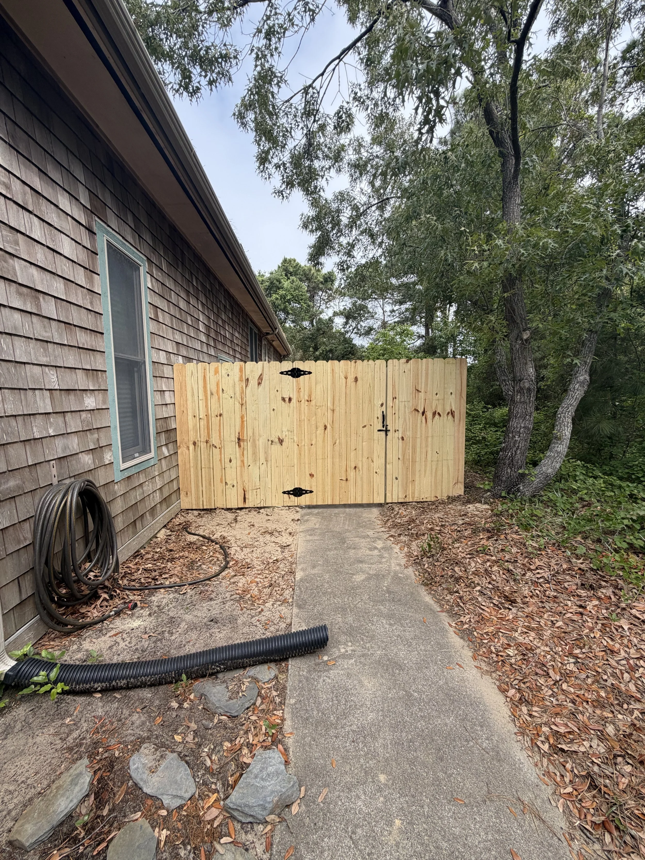 Completed custom wood privacy fence and double gate by Alpha Exteriors in the Outer Banks.