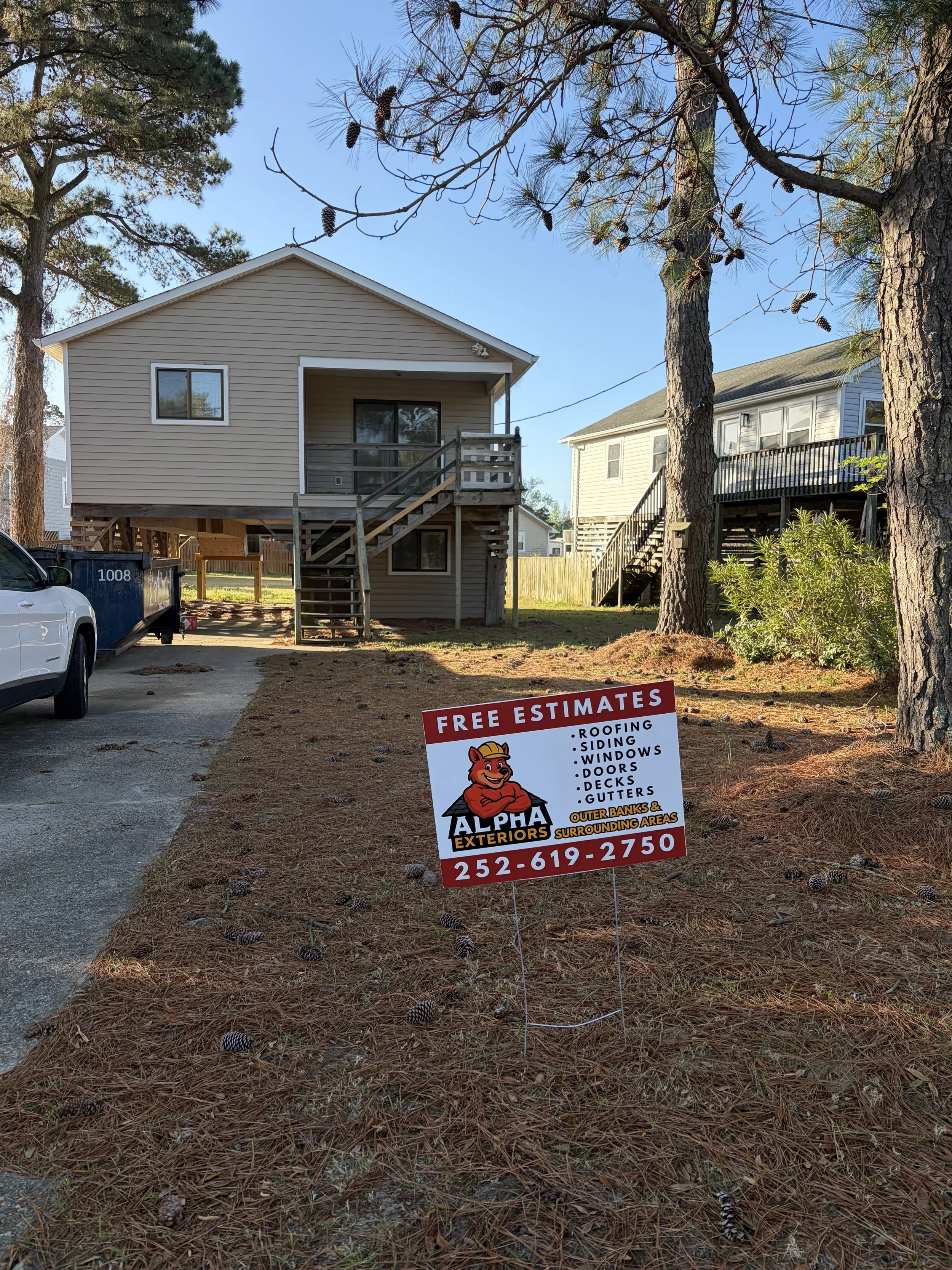 Alpha Exteriors yard sign advertising free estimates at an Outer Banks project.