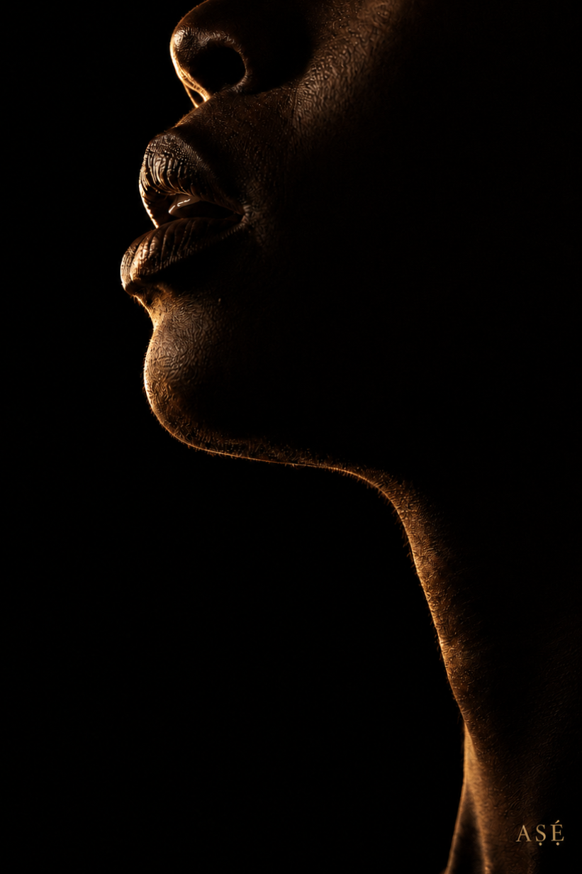 Close-up side profile of a person's face with dramatic lighting highlighting the lips, nose, and chin with dark background.