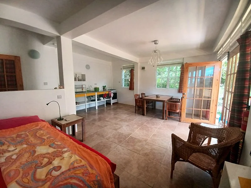 View from the bedroom area looking towards the open plan kitchen and dining area in the Jungle View Studio at Mango Garden Cottages