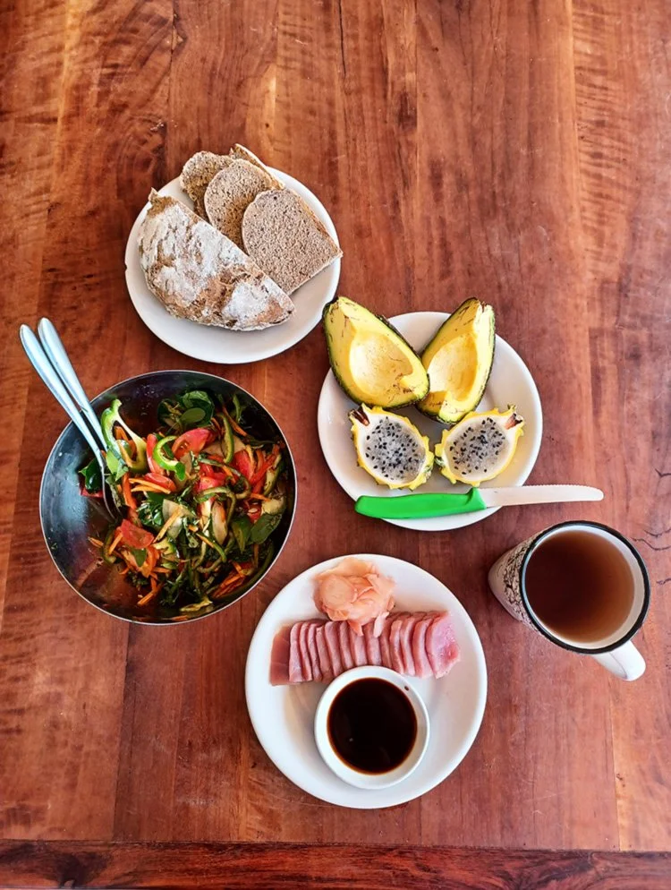 Fresh food from the garden for a light meal at Mango Garden Cottages, featuring freshly caught sushi and local fruits and vegetables with freshly baked bread