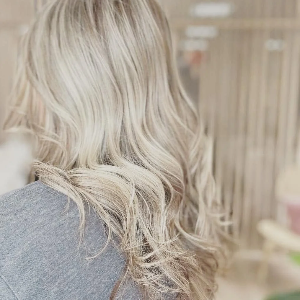 Back of a person with long, blonde, wavy hair.
