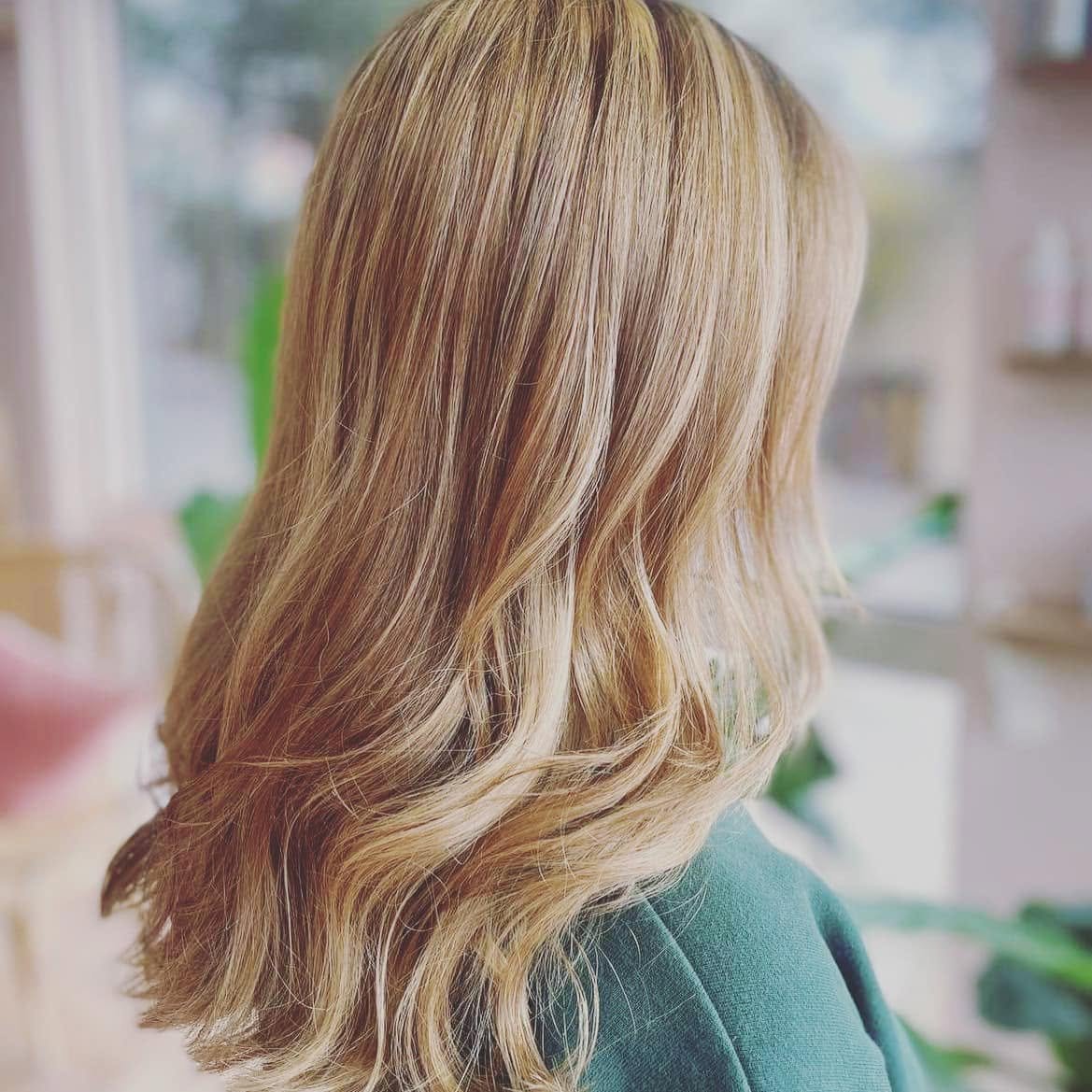 Back view of a woman's blonde, wavy hair.