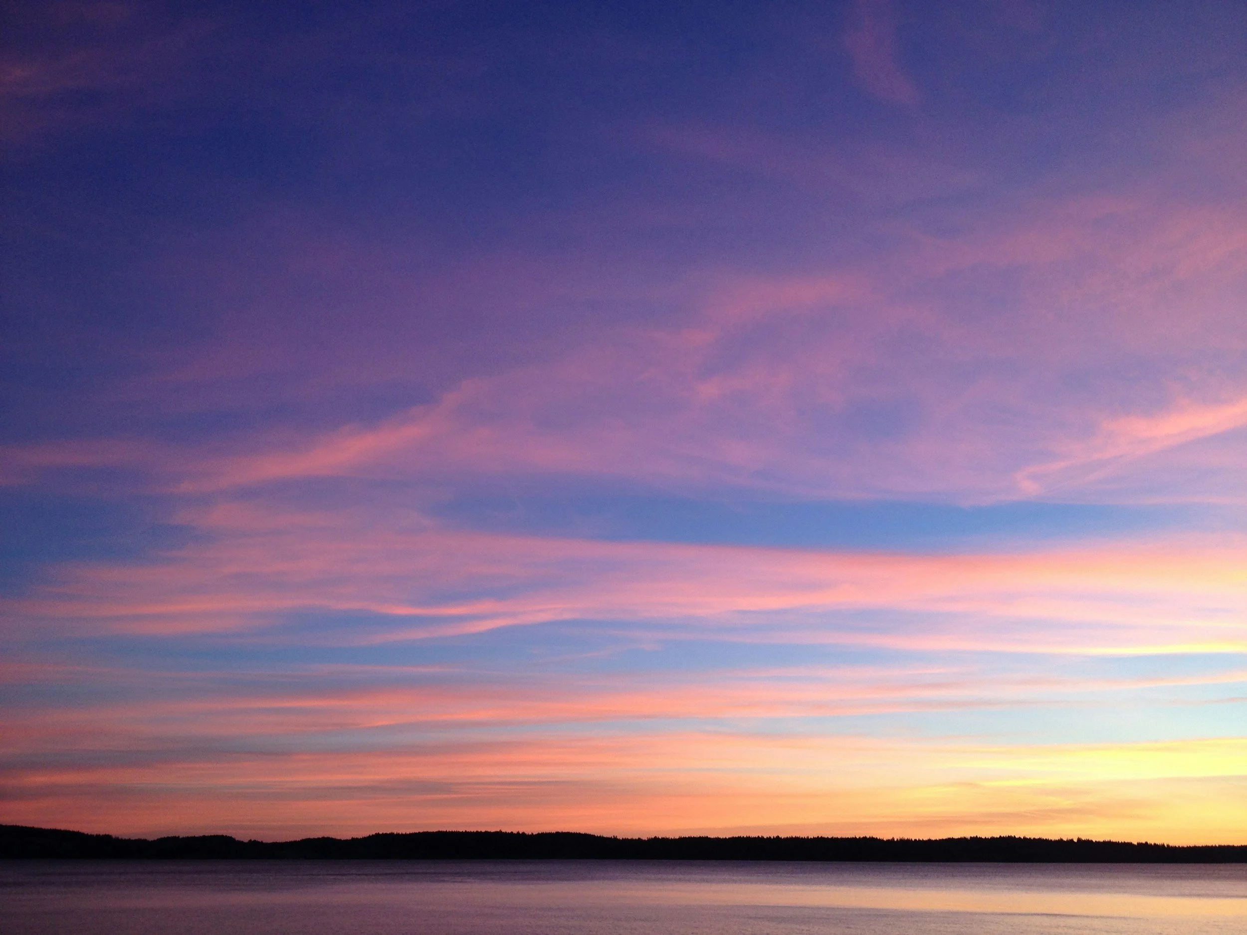 Colourful sky (blue, purple, pink, yellow) with wispy clouds.