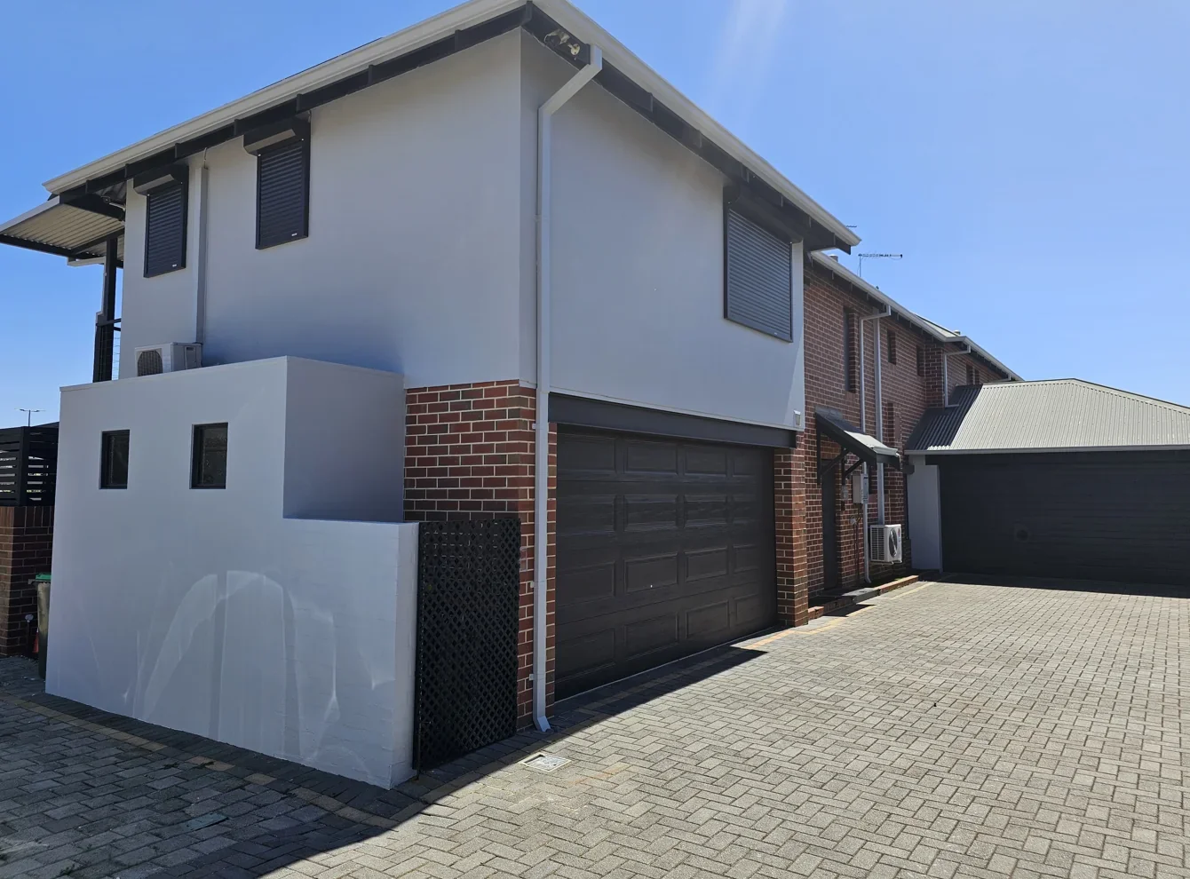 After: Blue-grey walls refreshed in a light neutral shade, with dark garage and roof details.