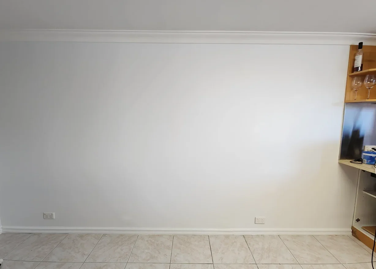 After: A wall with visible damage and patching brought back to a clean, consistent painted finish.