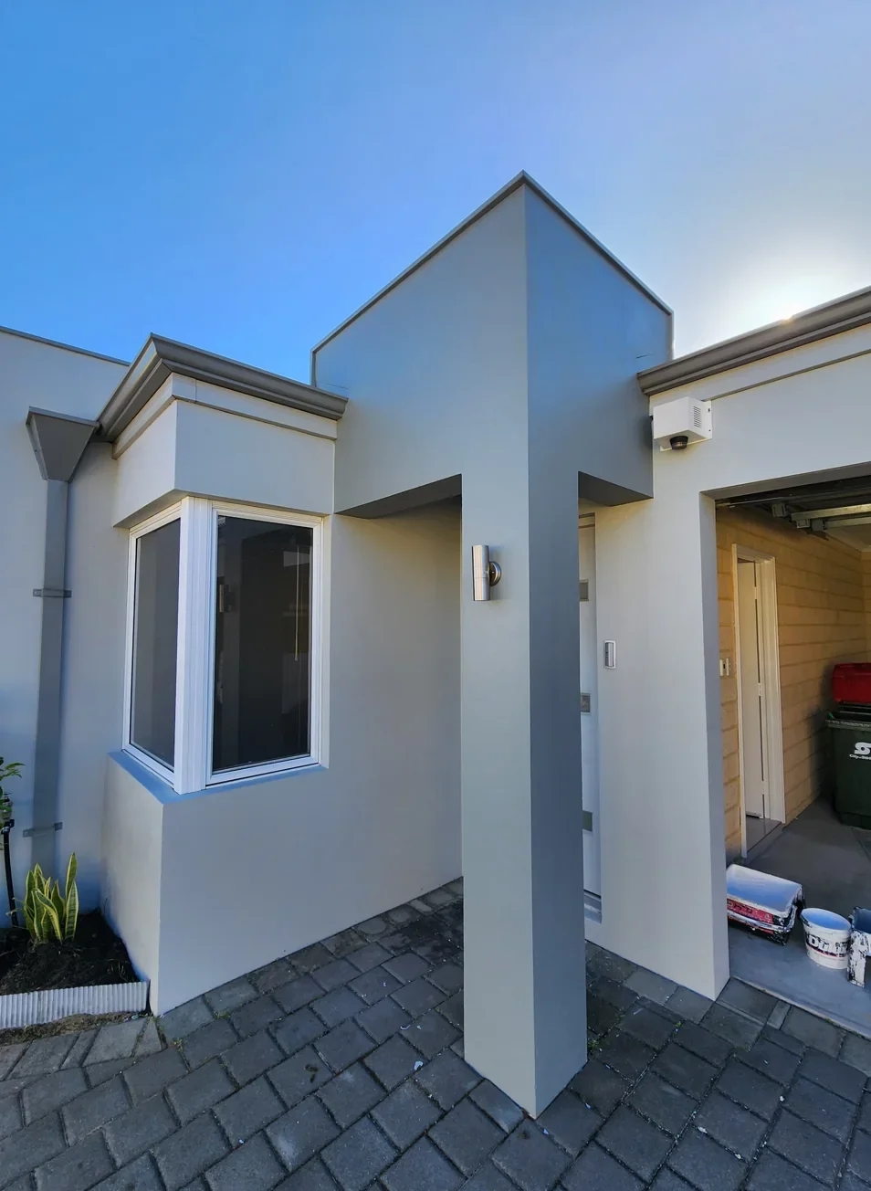 After: Weathered rendered walls and columns refreshed in a coordinated grey palette.