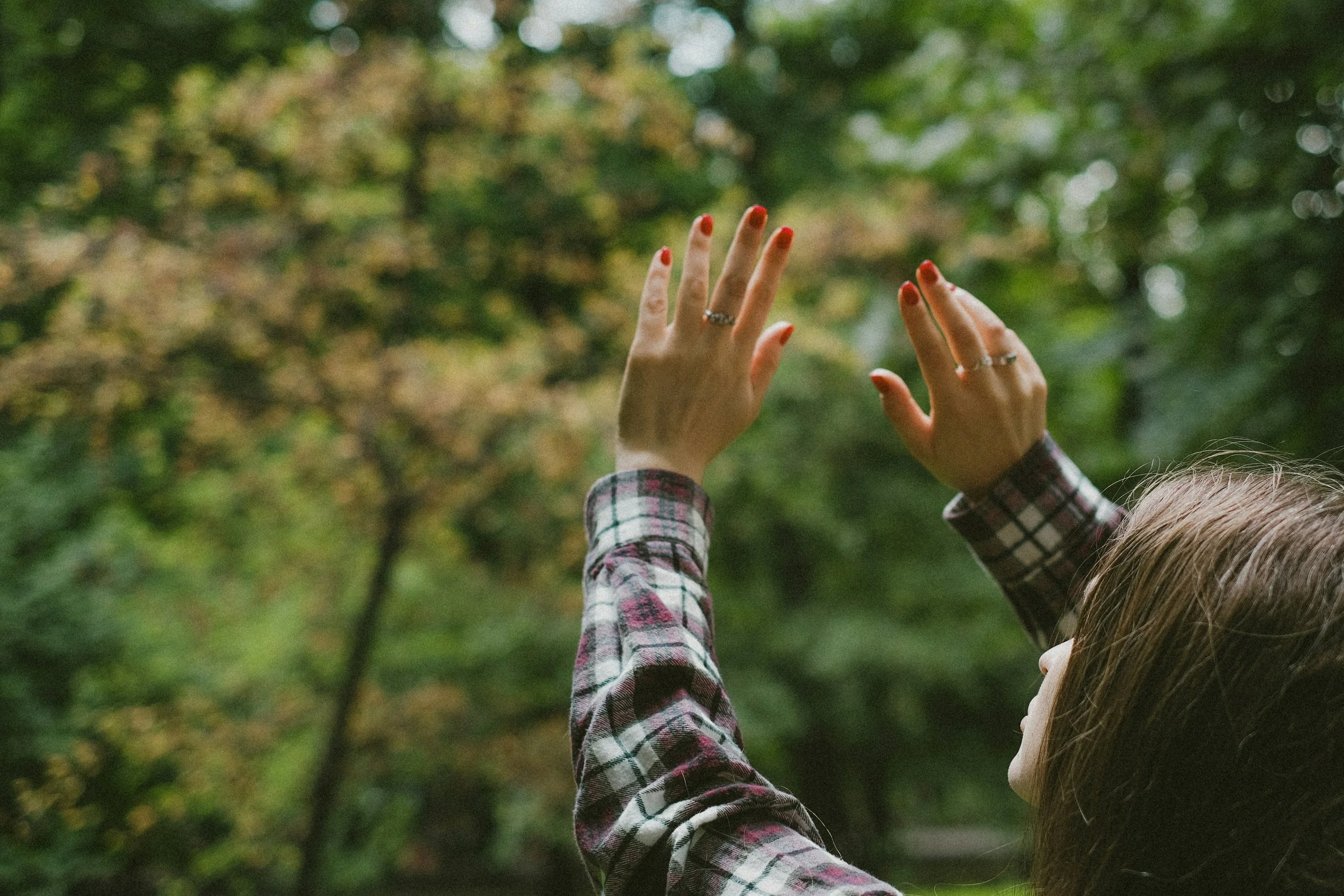 Woman examining her hands outdoors in autumn