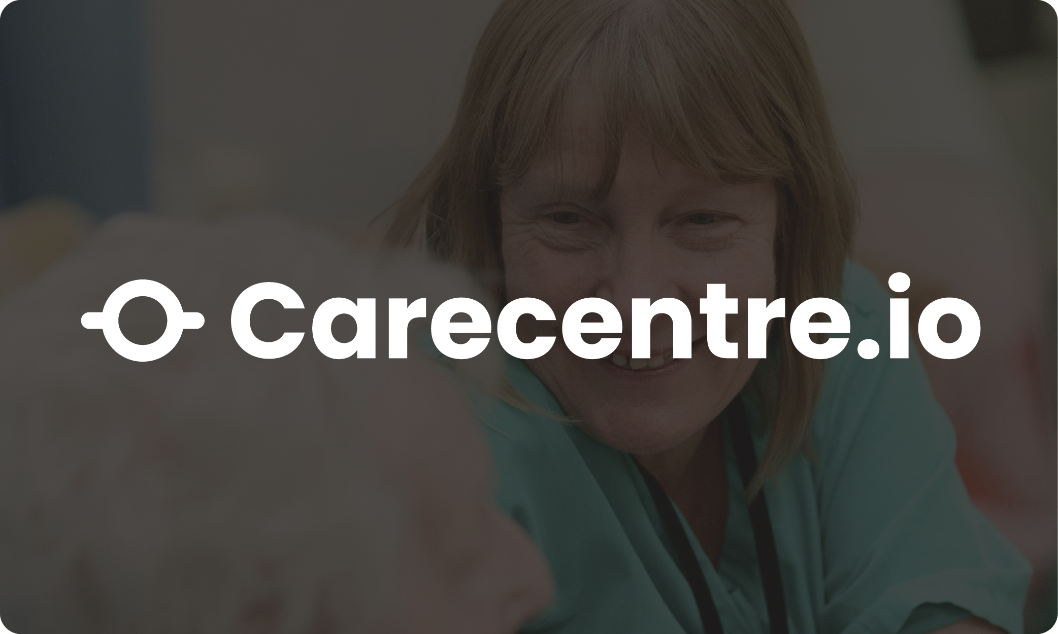 An elderly woman with red hair is smiling as she leans forward, engaging in a close interaction. Overlaid text says 'Carecentre.io' in logo form.