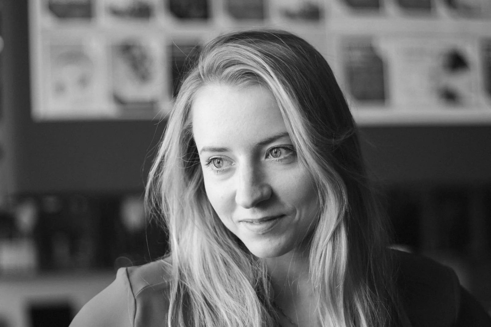 Black and white photo of a woman with long wavy hair looking away.