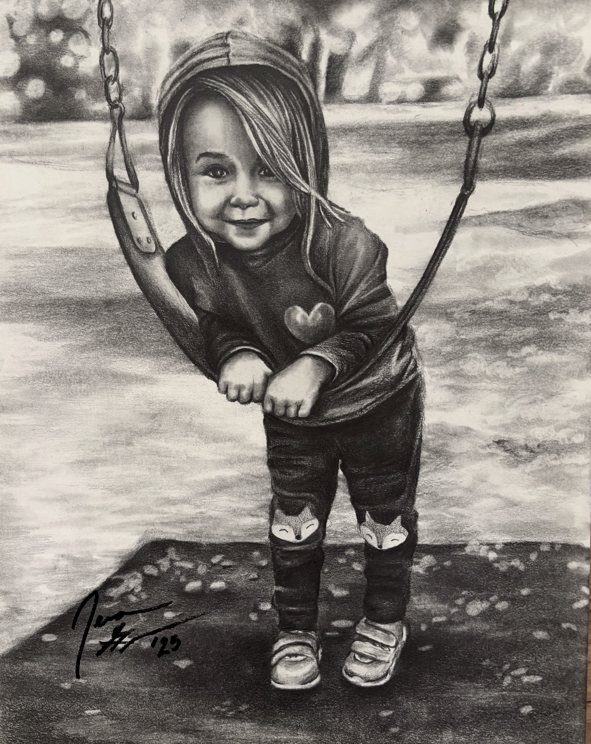 A detailed black and white drawing of a child on a swing set with a background of trees and sky, wearing a hoodie with a heart on it, striped hair, and sneakers, smiling at the camera.