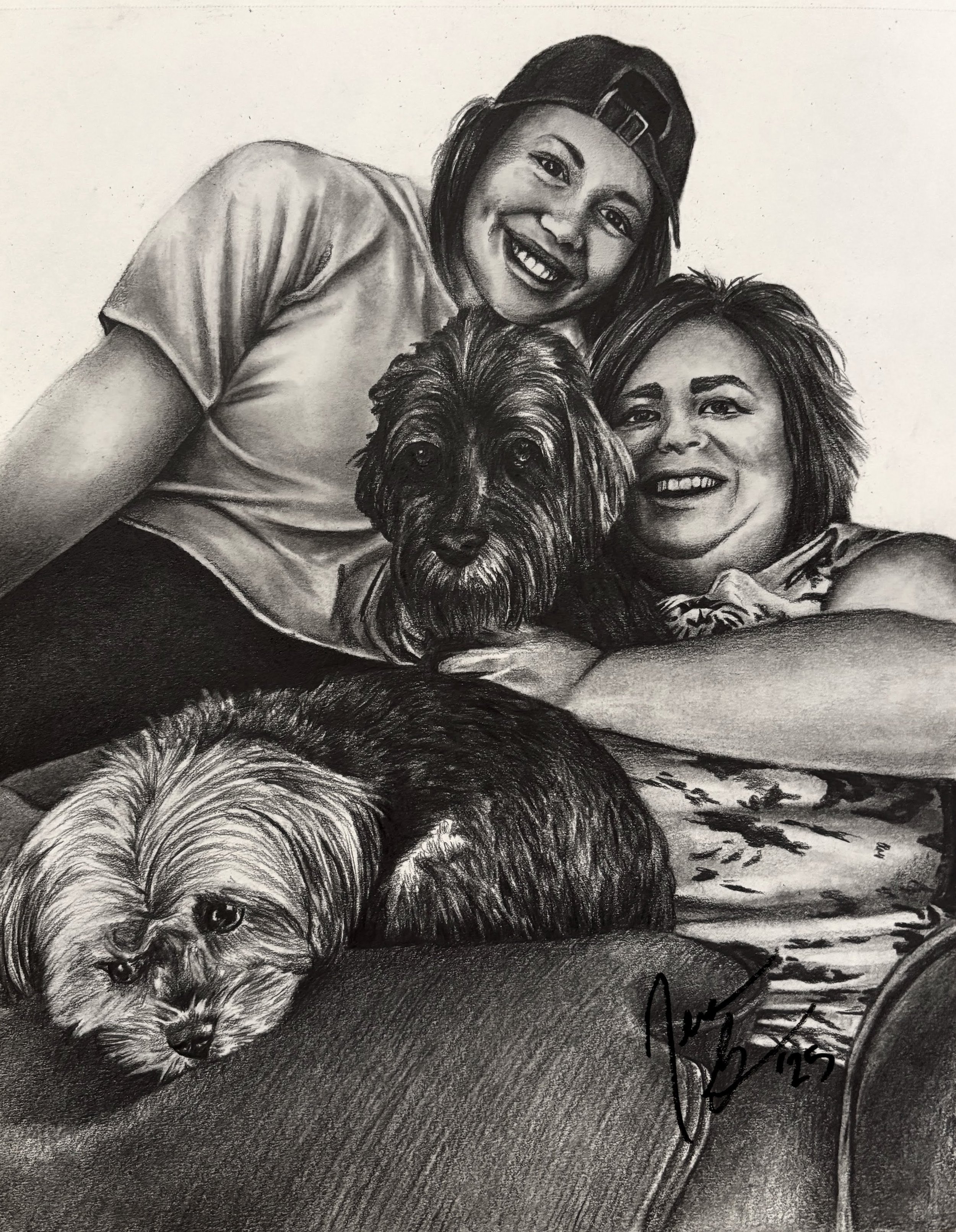A detailed black and white pencil drawing of two women with a dog, smiling and lying on the floor. The woman on the left is wearing a cap backwards and has medium-length hair, while the woman on the right has short, slightly messy hair. The dog has l