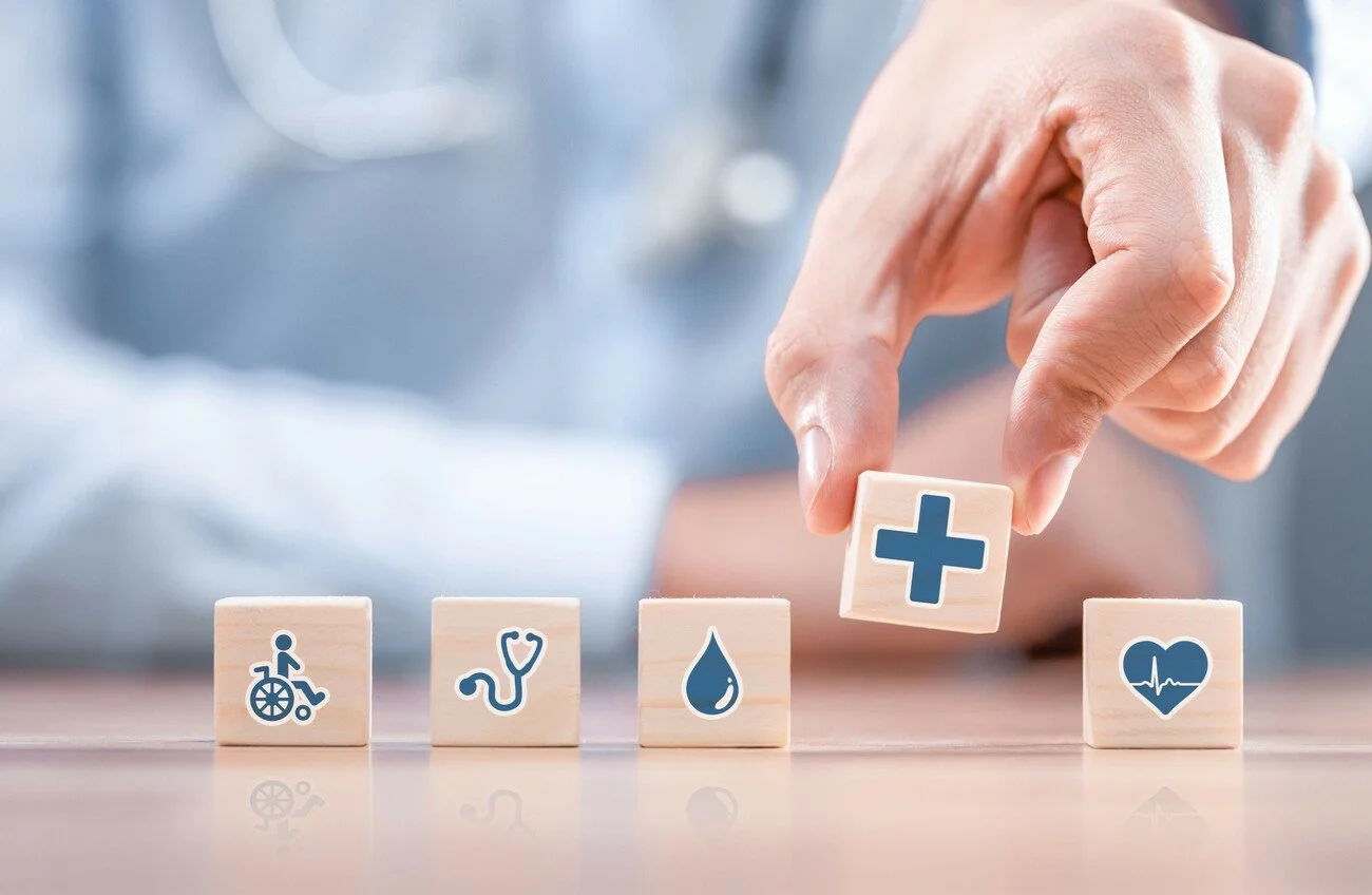 A disembodied hand holding a small wooden block above four other blocks