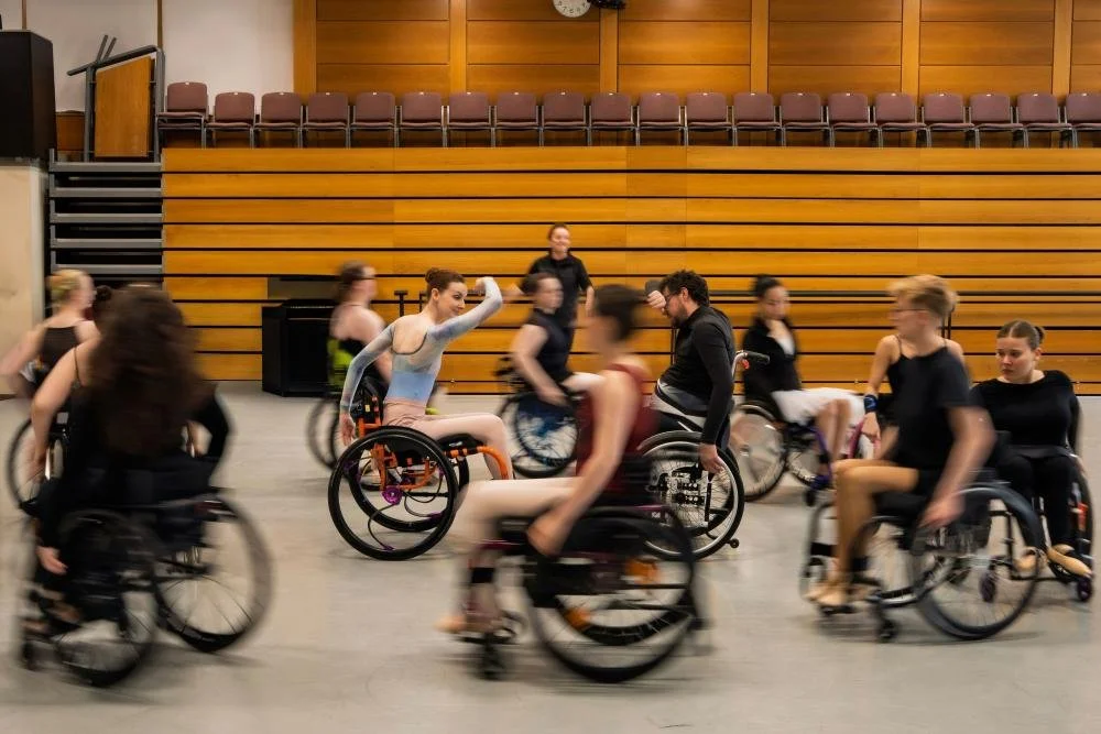 A group of wheelchair users moving in a dance class