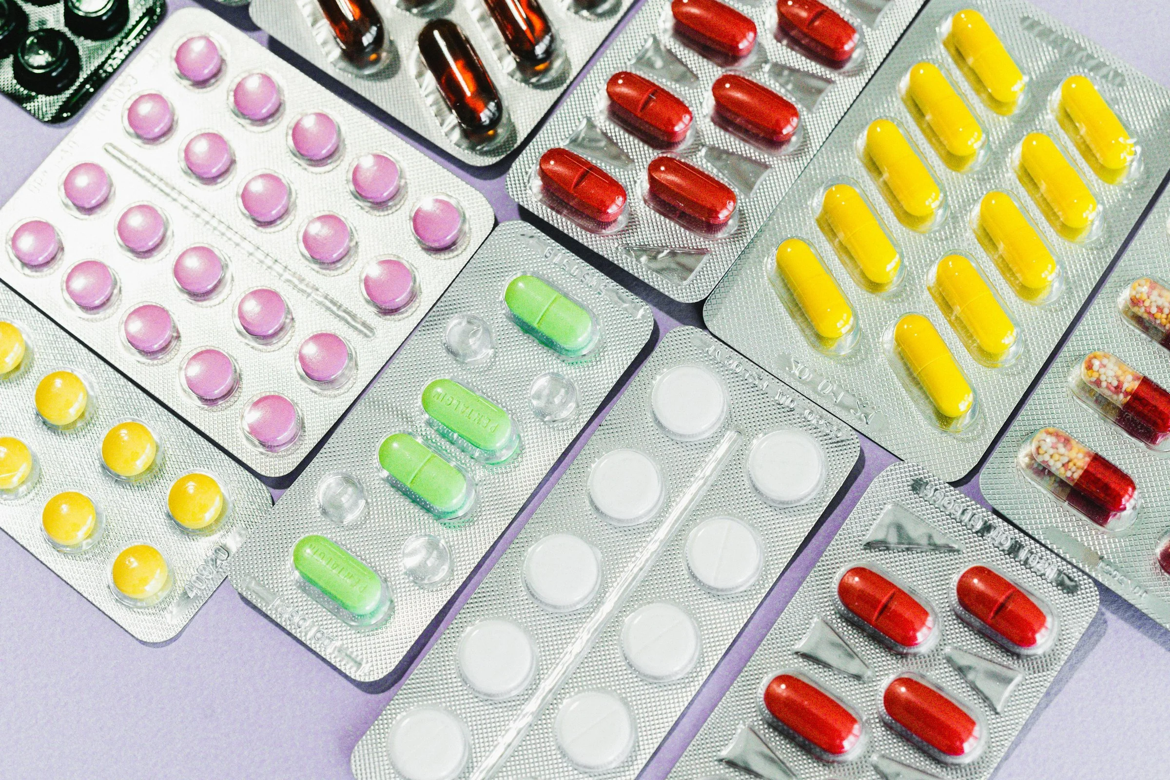 Multiple silver packets with colourful tablets.