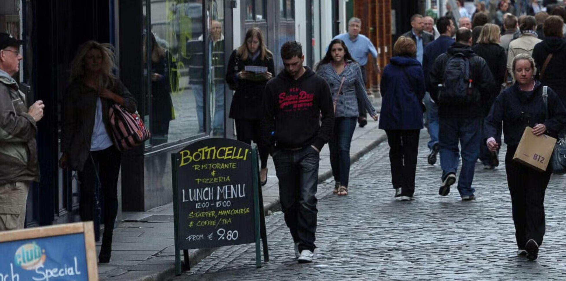 People walking on a cobble stone street in Dublin.