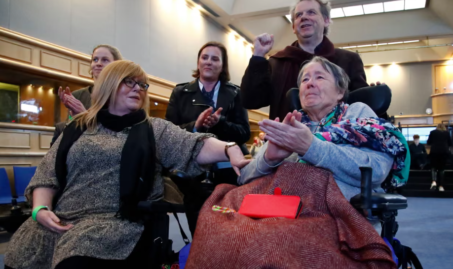 A group of people clapping and looking at something off camera