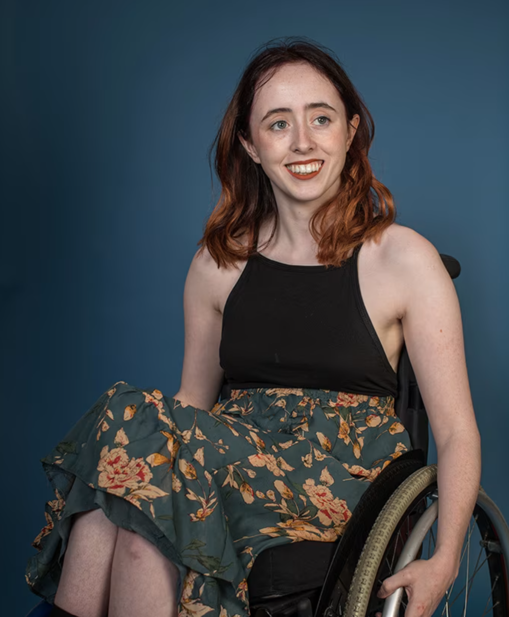 A woman (Niamh Ní Hoireabhaird) smiling and looking off-camera.