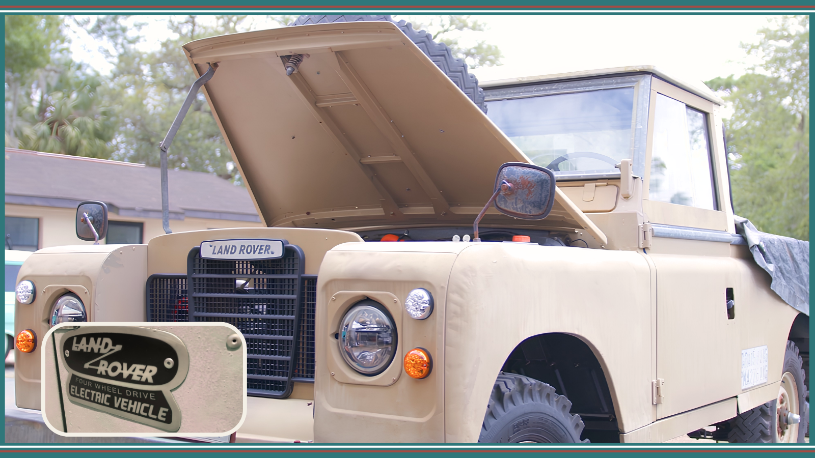 Beige Land Rover with its hood open and an electric vehicle badge on the front.