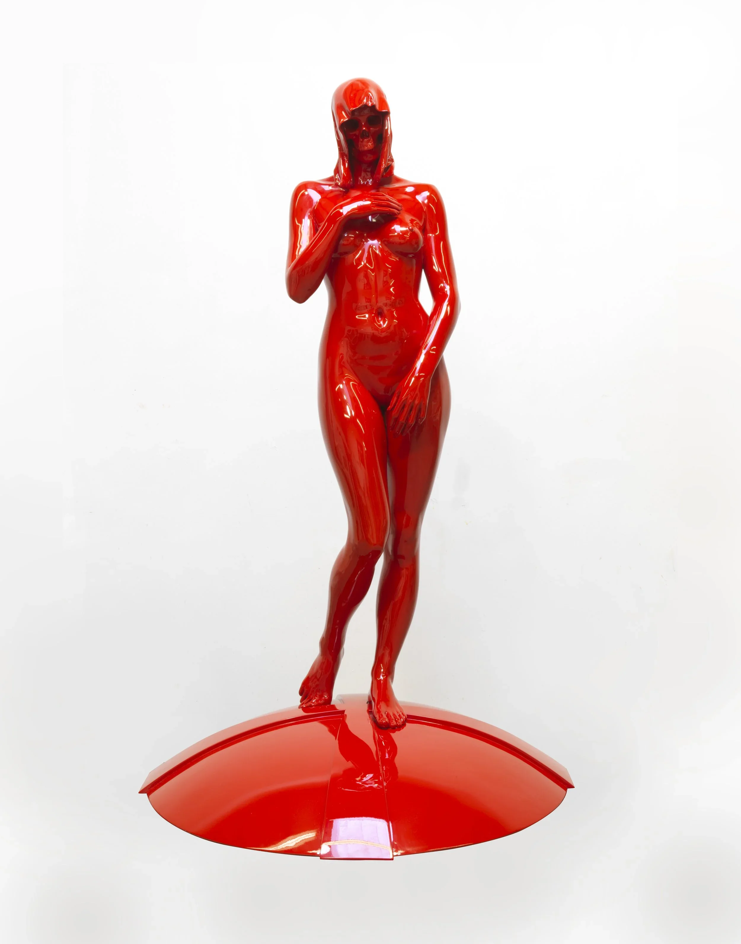 Contemporary glossy red sculpture of a standing female figure on a round red base