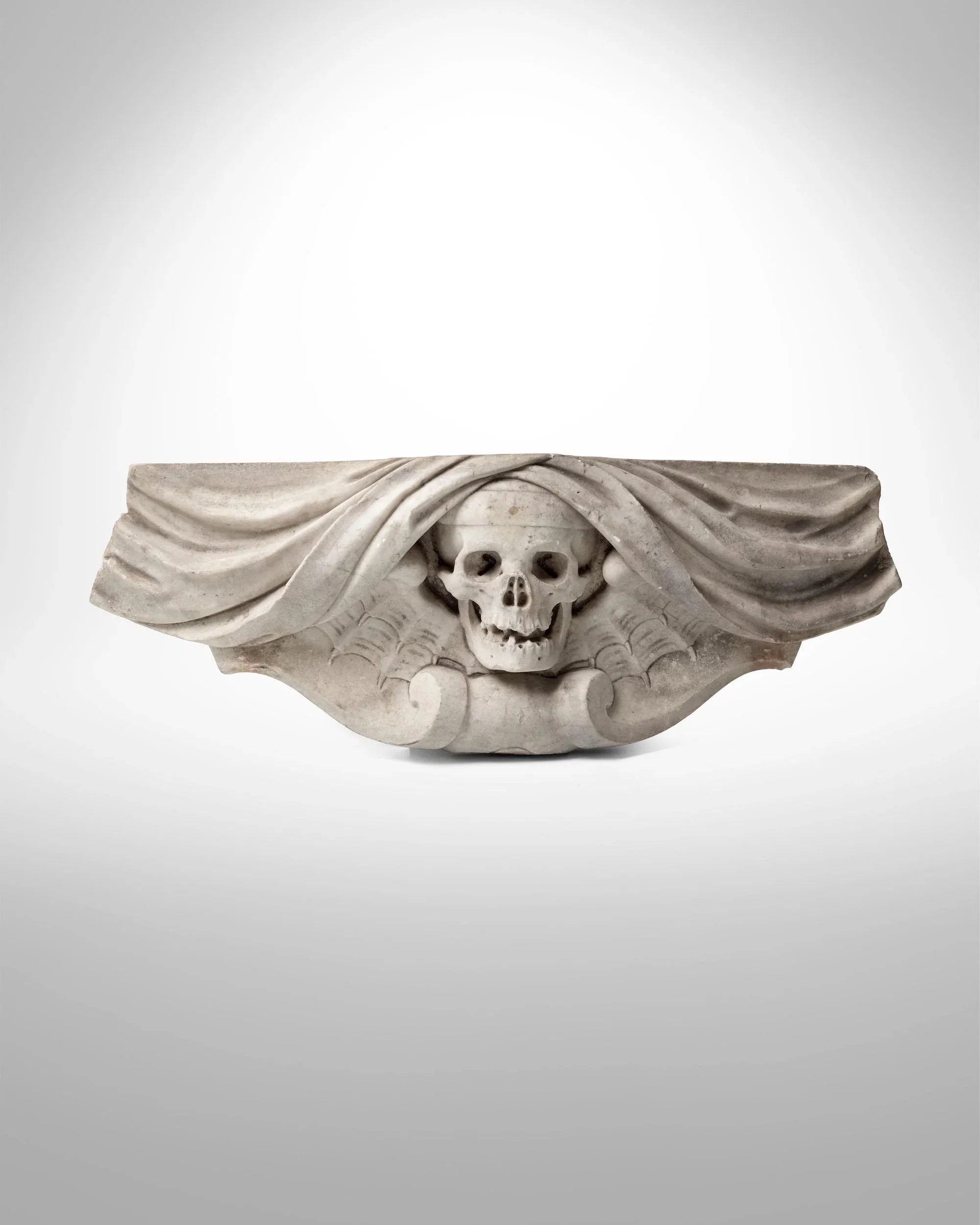 Carved white marble memento mori of a skull beneath draped cloth, France, 16th century