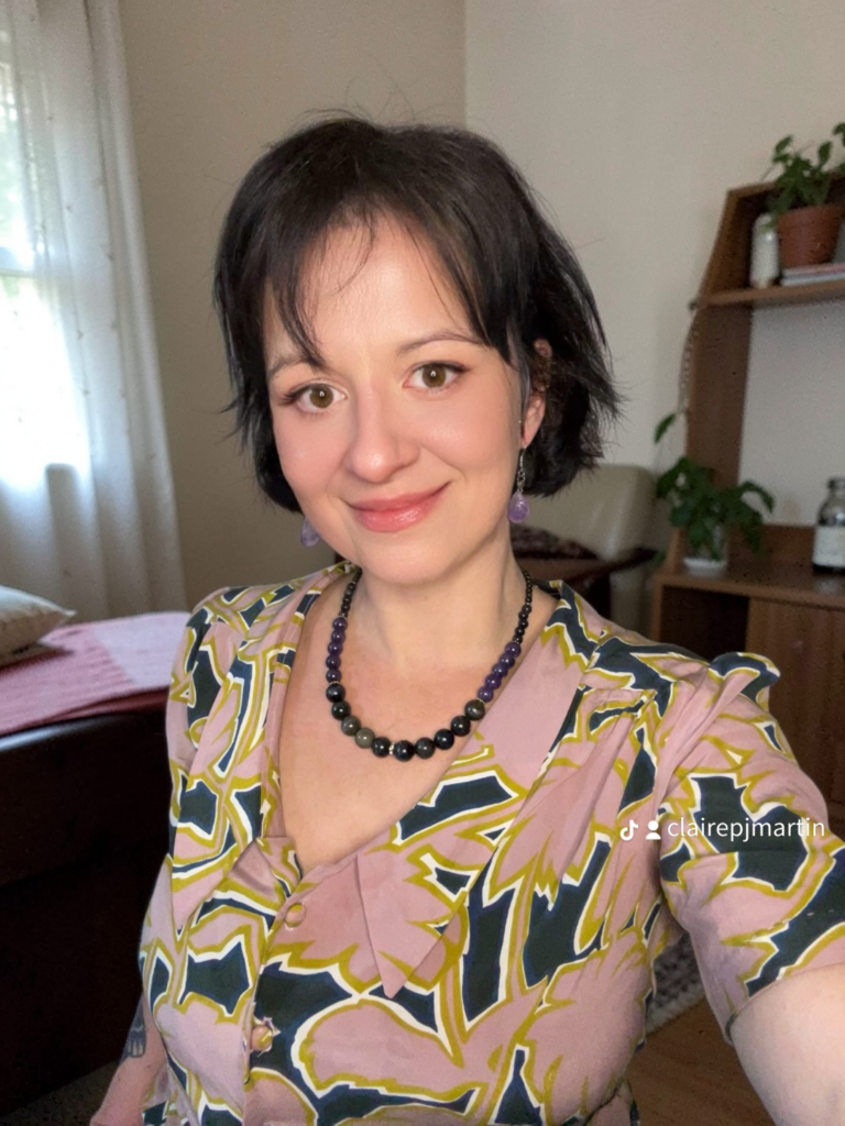 A picture of Claire, with a handmade silk shirt and handmade obsidian jewellery