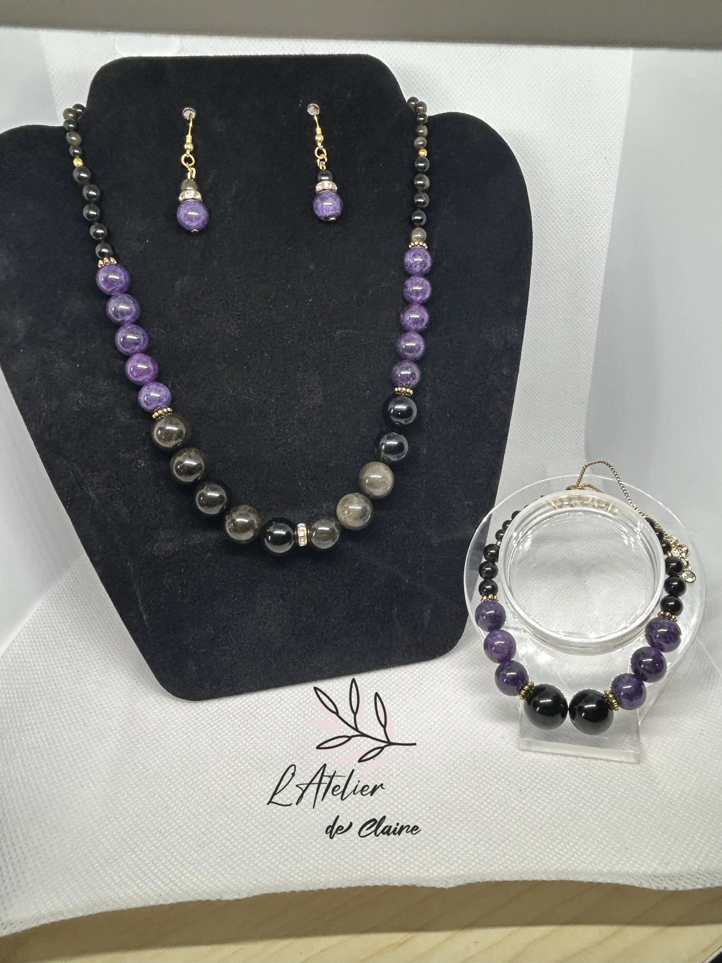 A necklace made with golden obsidian beads and amethyst beads, a matching bracelet and matching earrings