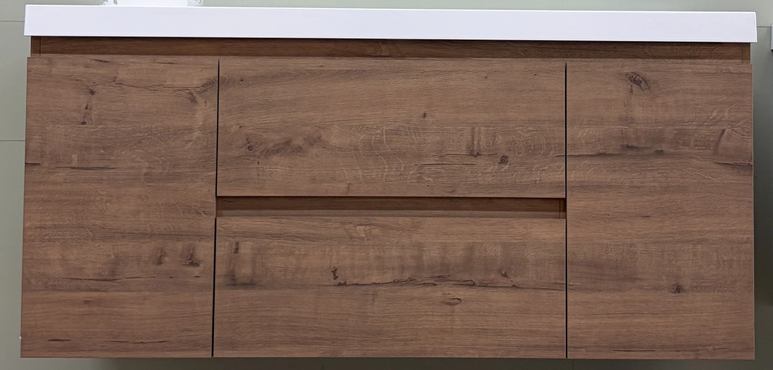 A wooden cabinet with multiple drawers and a white countertop.