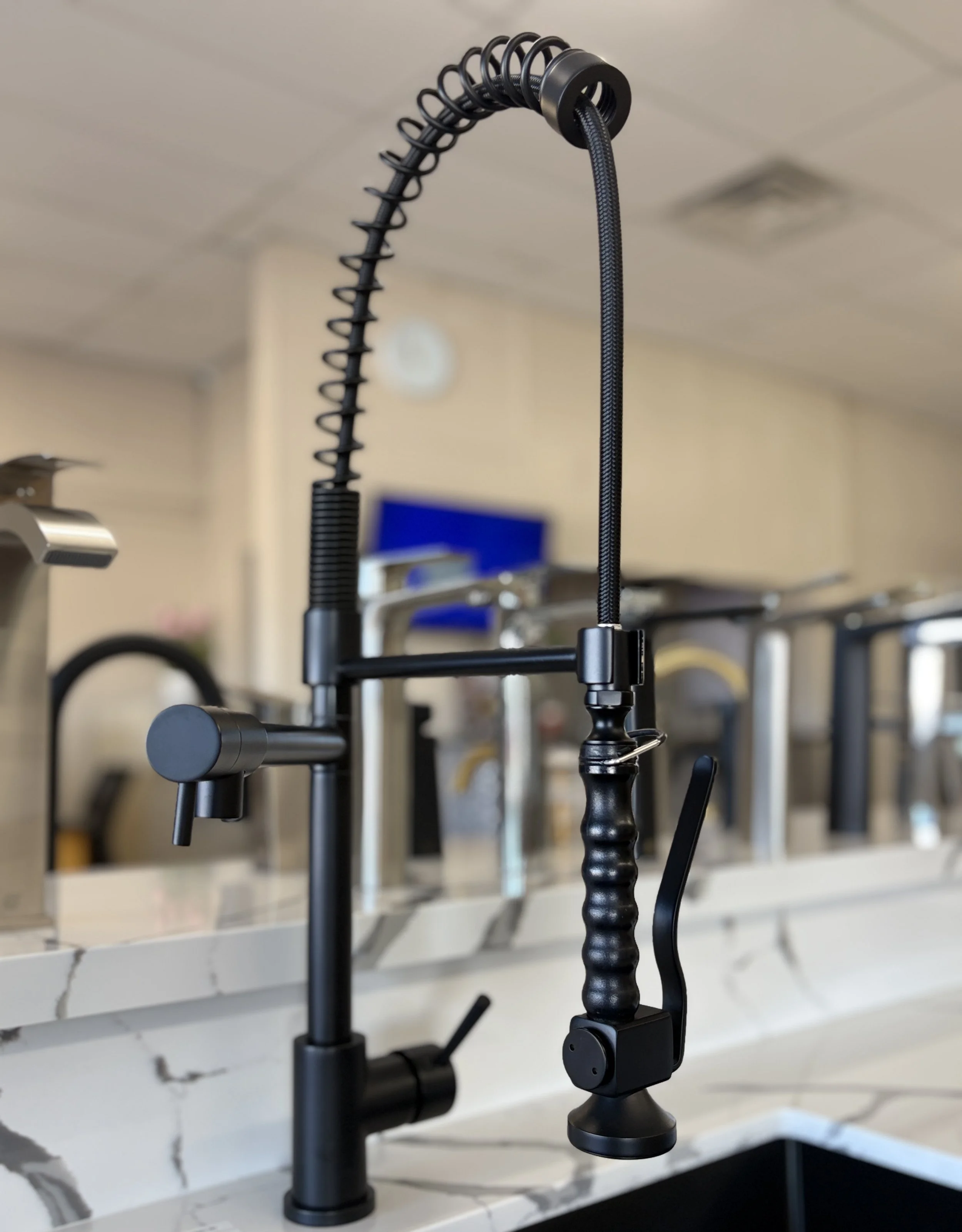 Close-up of a professional desk microphone with a flexible, coiled gooseneck stand on a white marble desk.