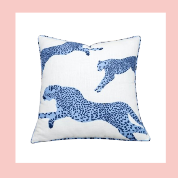 A decorative square pillow with a white background and blue leopard print pattern, featuring multiple leopards in different poses.