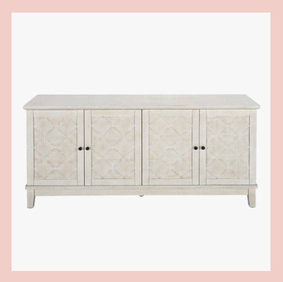 White wooden sideboard with four doors featuring a geometric star pattern, black knobs, and a slightly distressed finish.