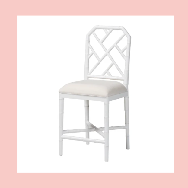 White banquette chair with a decorative geometric open back and a cushioned seat, against a white background with a pink border.